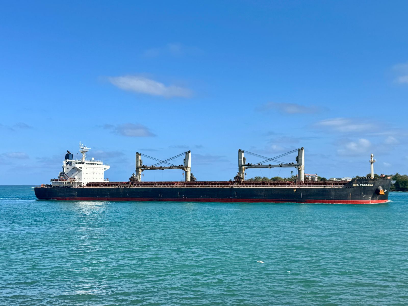 A cargo ship at sea under a clear sky