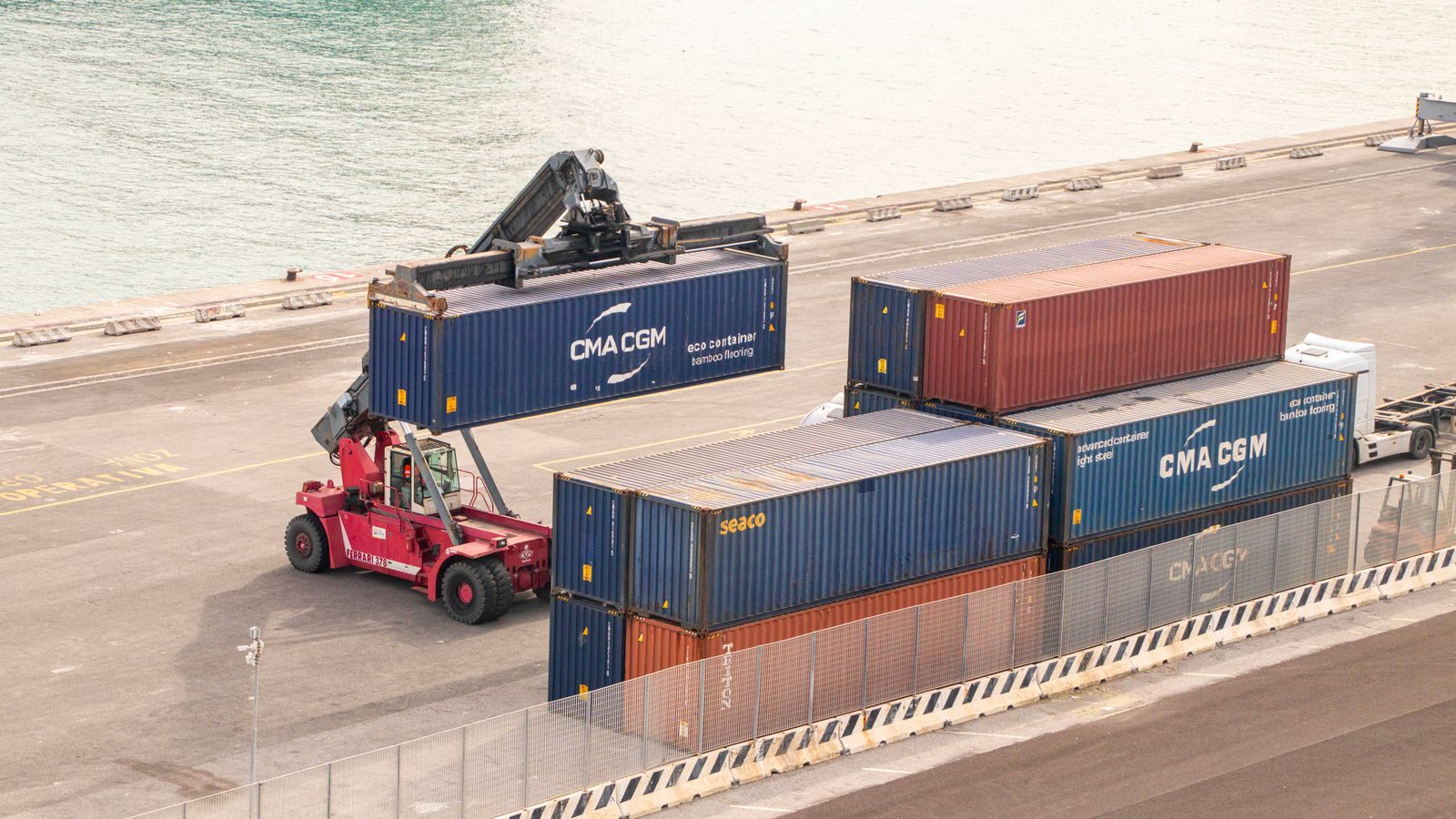 A reach stacker moving shipping containers on a wharf