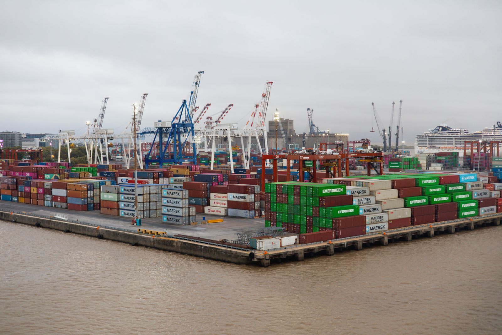 Aerial view of a container port with stacked containers and cranes